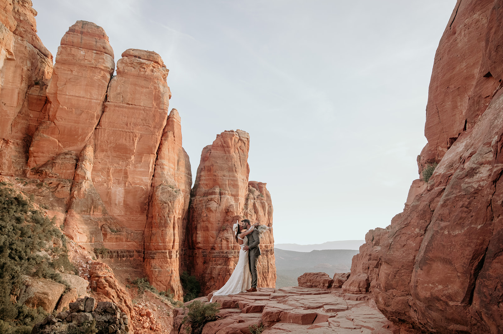 Bride and groom on the edge of Cathedral Rock at their Sedona elopement.