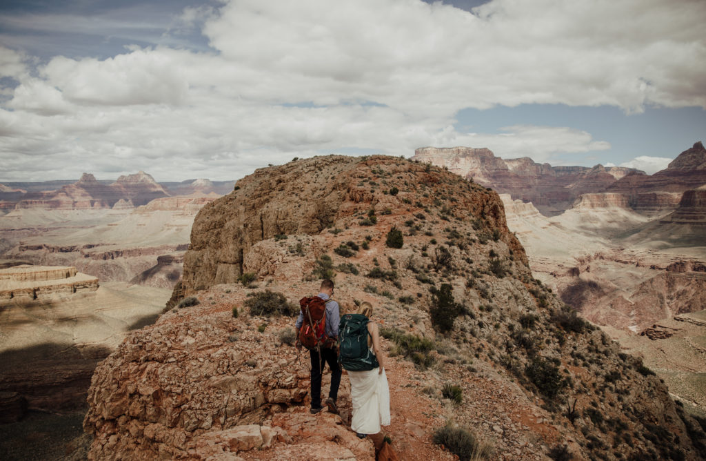 Bride and groom hiking to the wedding location in the Grand Canyon.