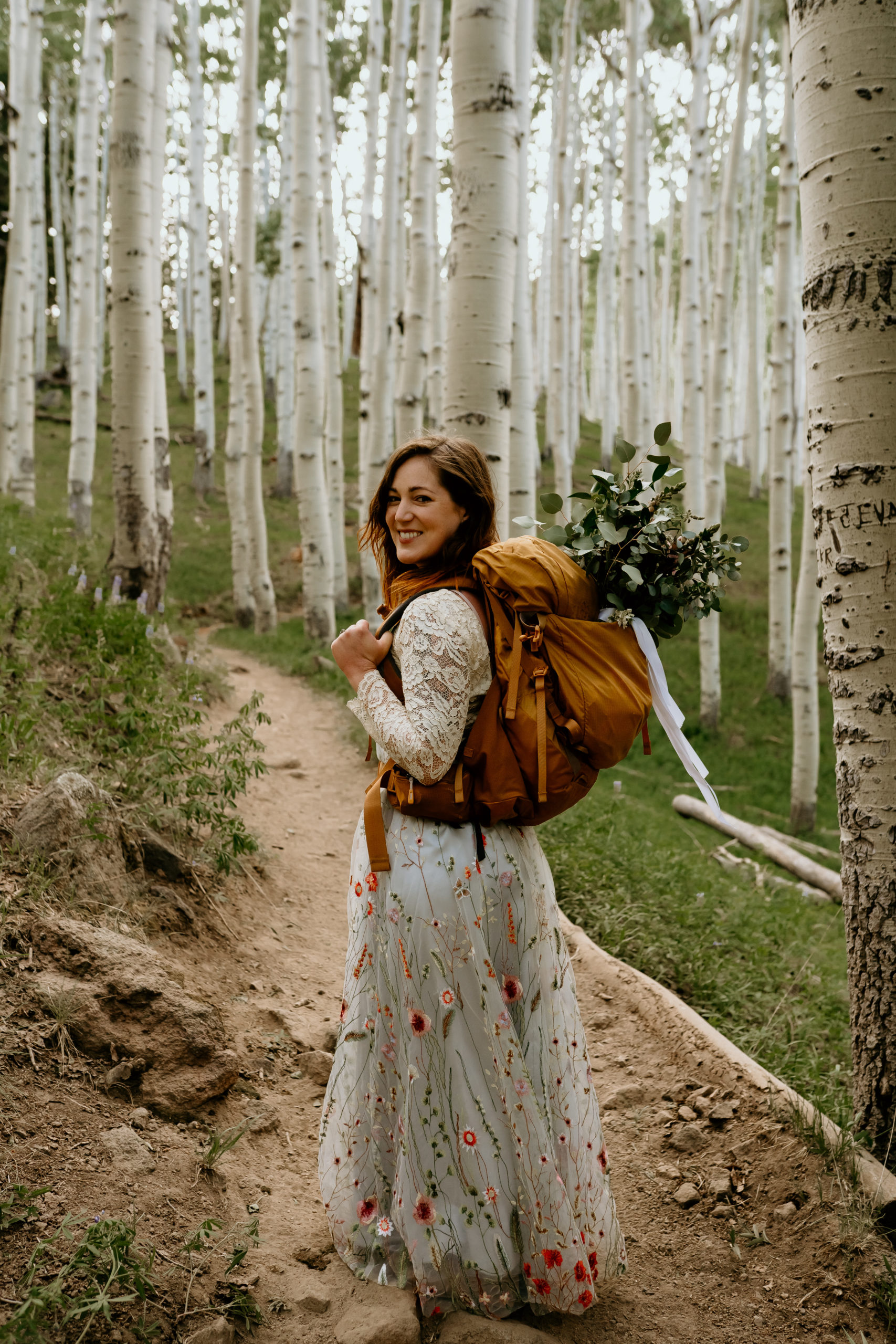 bride hiking in her wedding dress at her colorado elopement in the mountains