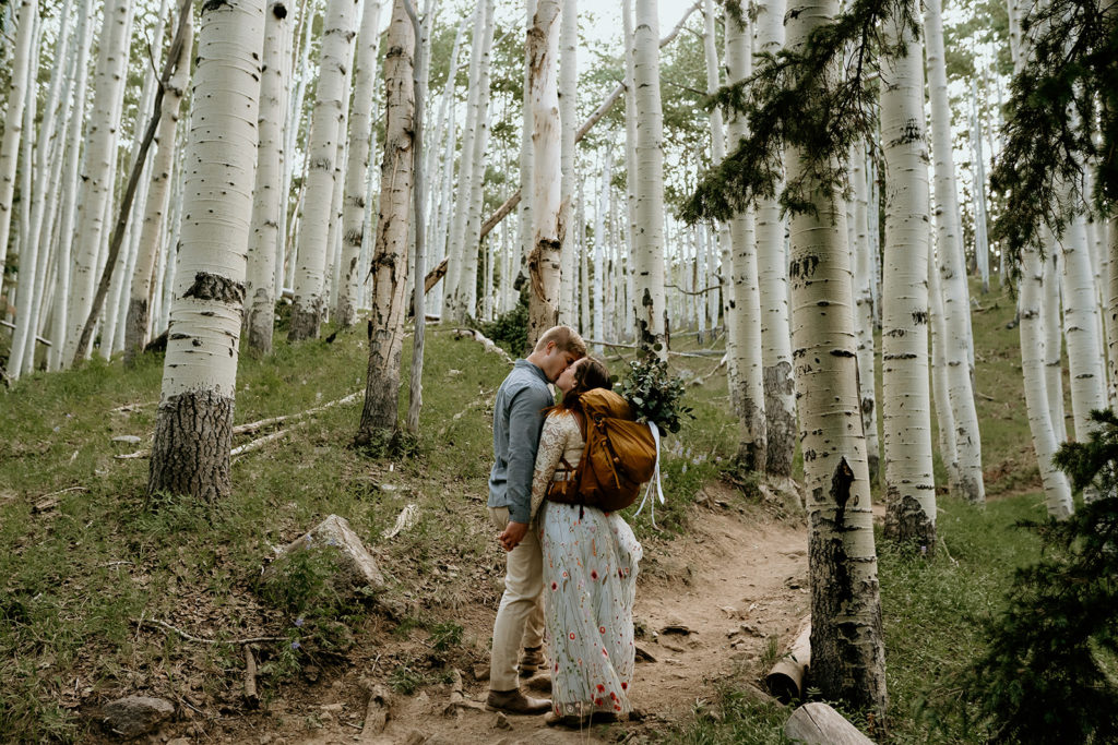 bride and groom hiking in aspen grove on their elopement day
