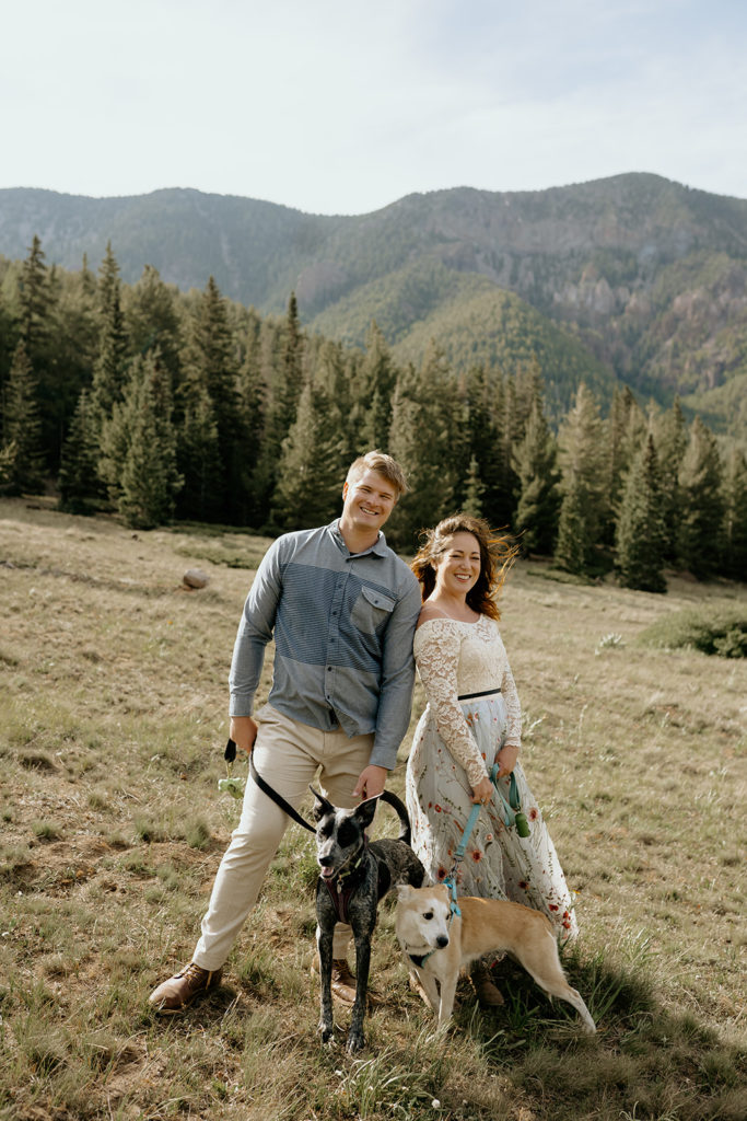 bride and groom with their dogs at the elopement in a meadow