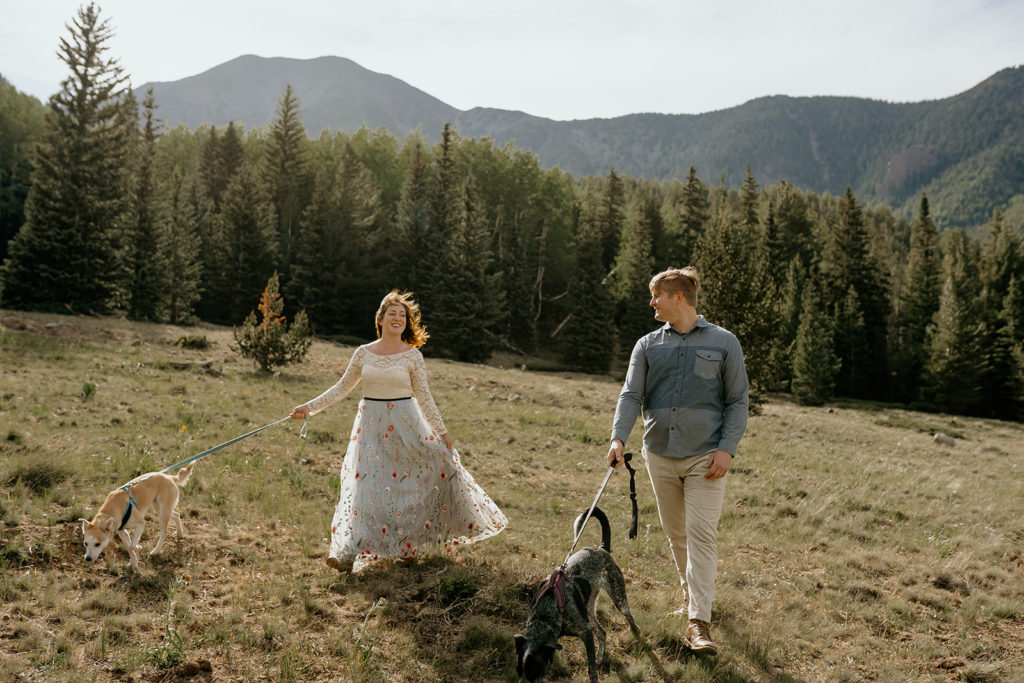 bride and groom hiking with the dogs in the mountains on their wedding day