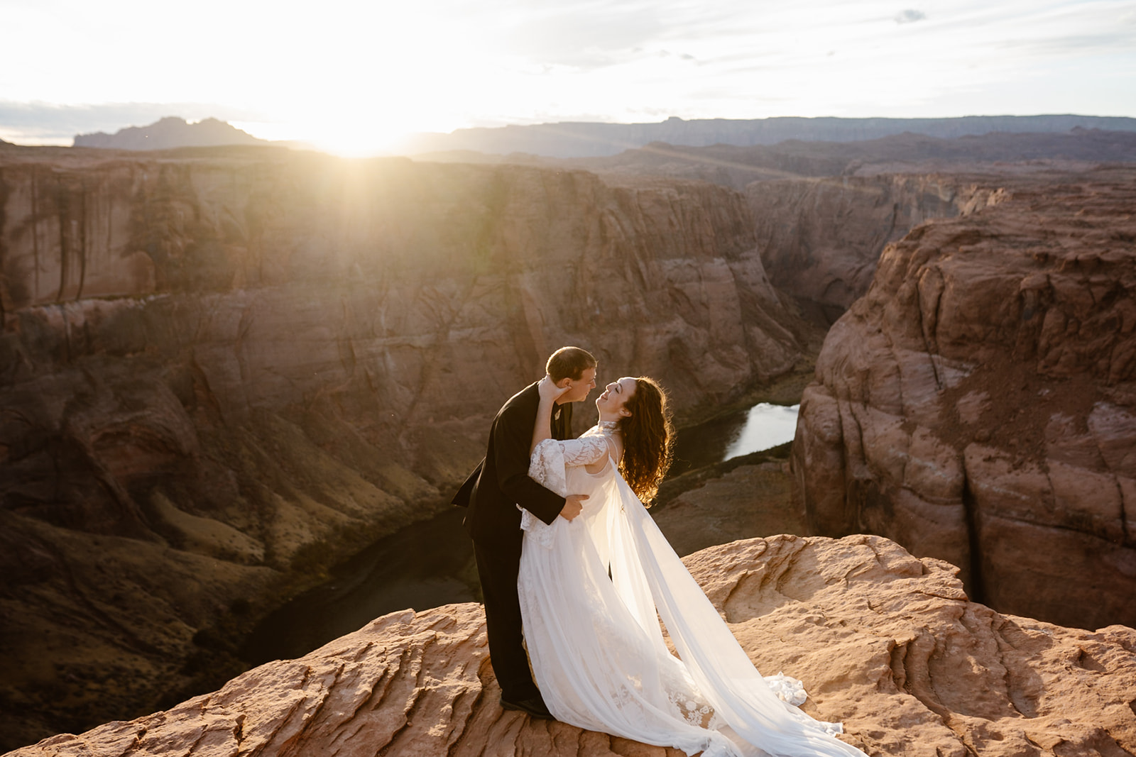 bride and groom kissing at sunset at horseshoe bend on their wedding day