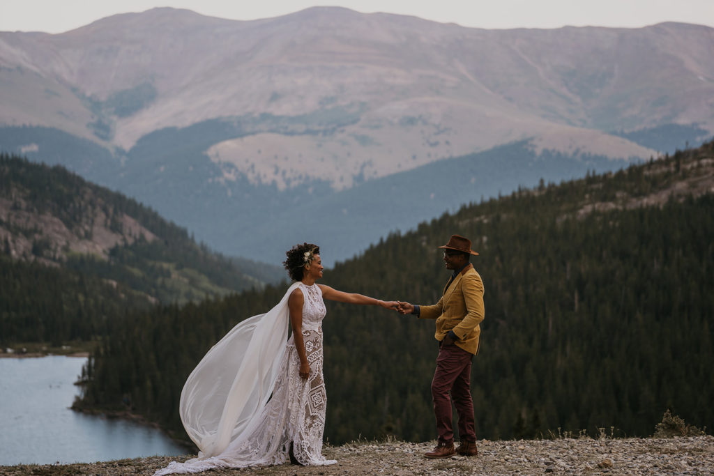 Bride and groom looking at each other with smiles with a lake in the background at their elopement in Breckenridge Colorado
