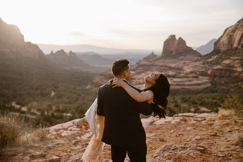 bride and groom laughing with red mountains in the background in sedona arizona 
