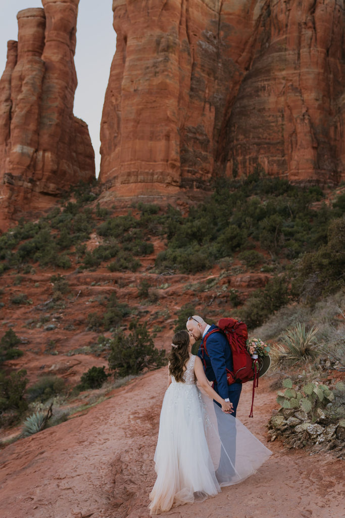 bride and groom kissing on a hike at their sedona elopement at cathedral rock
