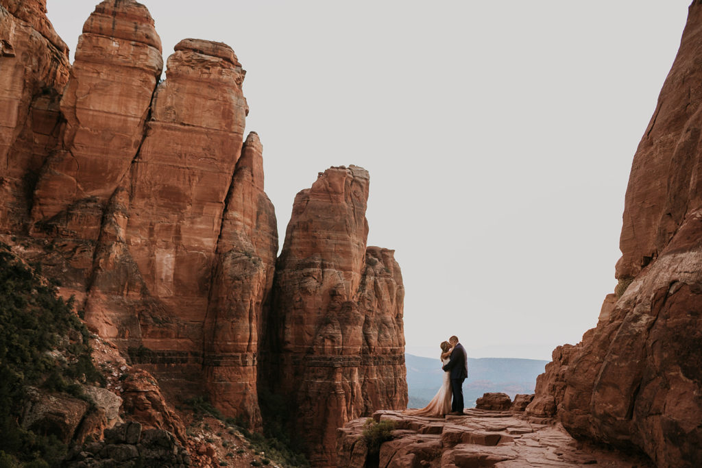 bride and groom kissing on a red cliff in sedona, arizona