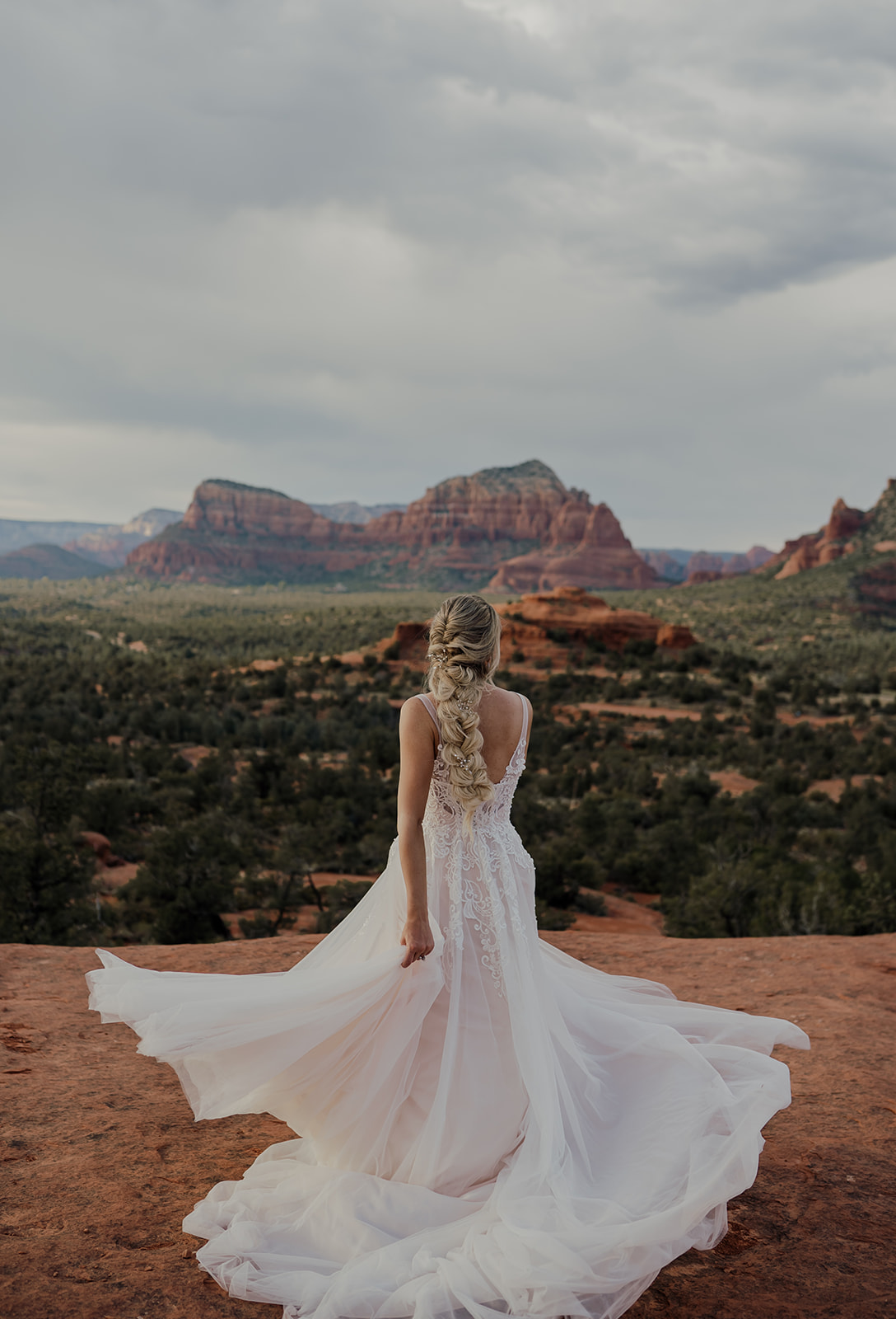 bride spinning in flowy wedding dress with long blonde braid in sedona arizona