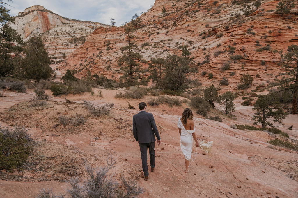 bride and groom walking barefoot in the desert