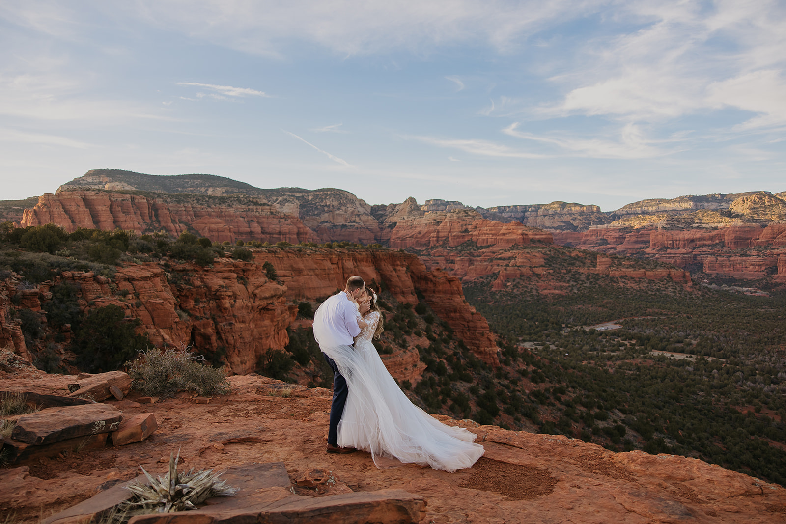 bride and groom kissing at sunset on red mountain in sedona arizona