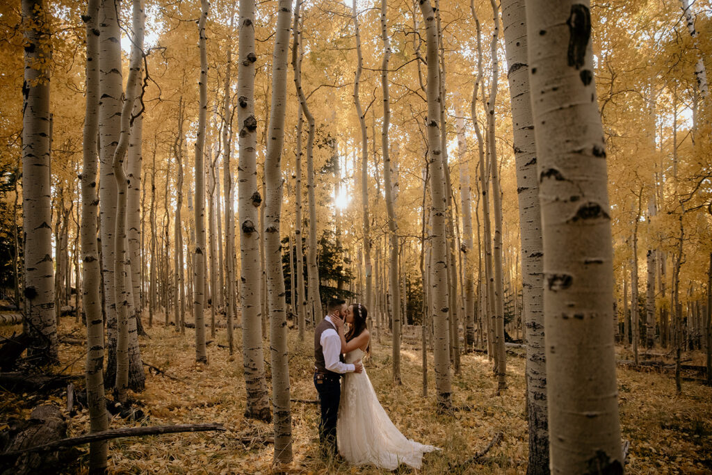 couple kissing at their wedding in flagstaff in the golden aspen trees