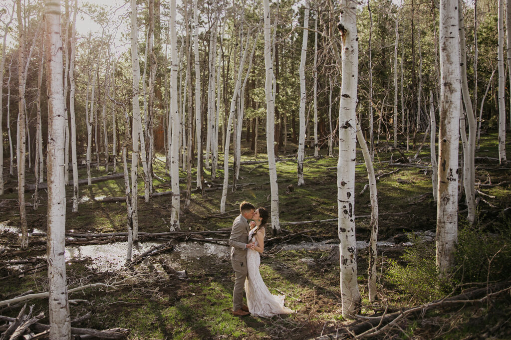 couple kissing at their wedding in the aspens in flagstaff arizona
